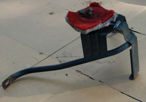1988 Ford Bronco - A metal bracket with a red buffing pad is shown against a cardboard background.