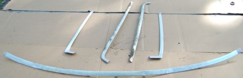 1988 Ford Bronco - Various metal trim pieces are displayed on a flat surface, possibly for restoration or sale.