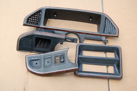 1988 Ford Bronco - Several dashboard trim components are laid out on a cardboard surface.