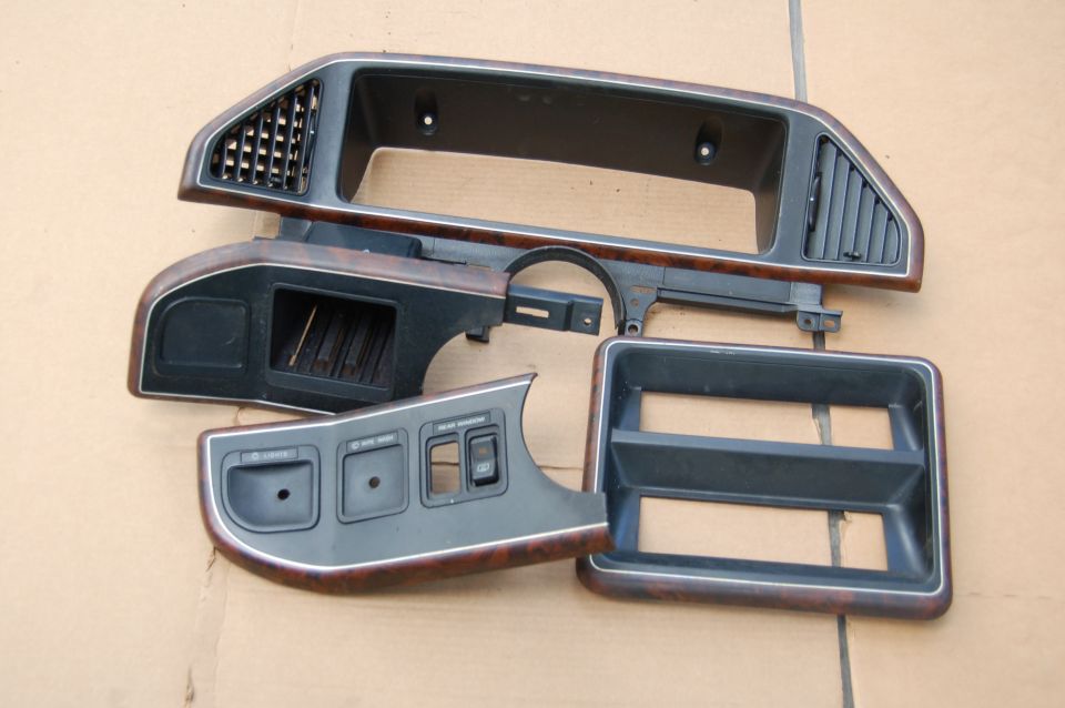 Dashboard trim pieces with wood grain accents and air vents