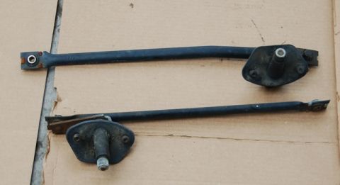1988 Ford Bronco - Pair of windshield wiper arms and their bases, photographed on a flat surface.