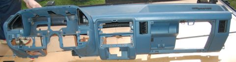 1988 Ford Bronco - A blue dashboard assembly, likely removed from a vehicle for repair or replacement, is laid out for inspection.