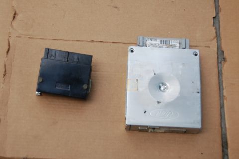 1988 Ford Bronco - Two electronic automotive parts, likely an ECU and its connector, are shown on a cardboard surface.