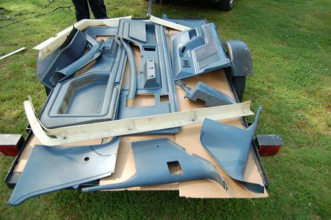 1988 Ford Bronco - Various interior trim pieces are organized on a trailer, ready for transport or installation.