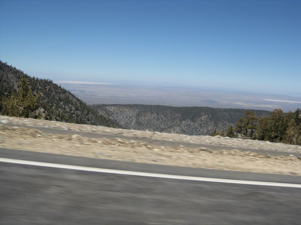 Roadside view of a mountain landscape with a clear blue sky and distant valley