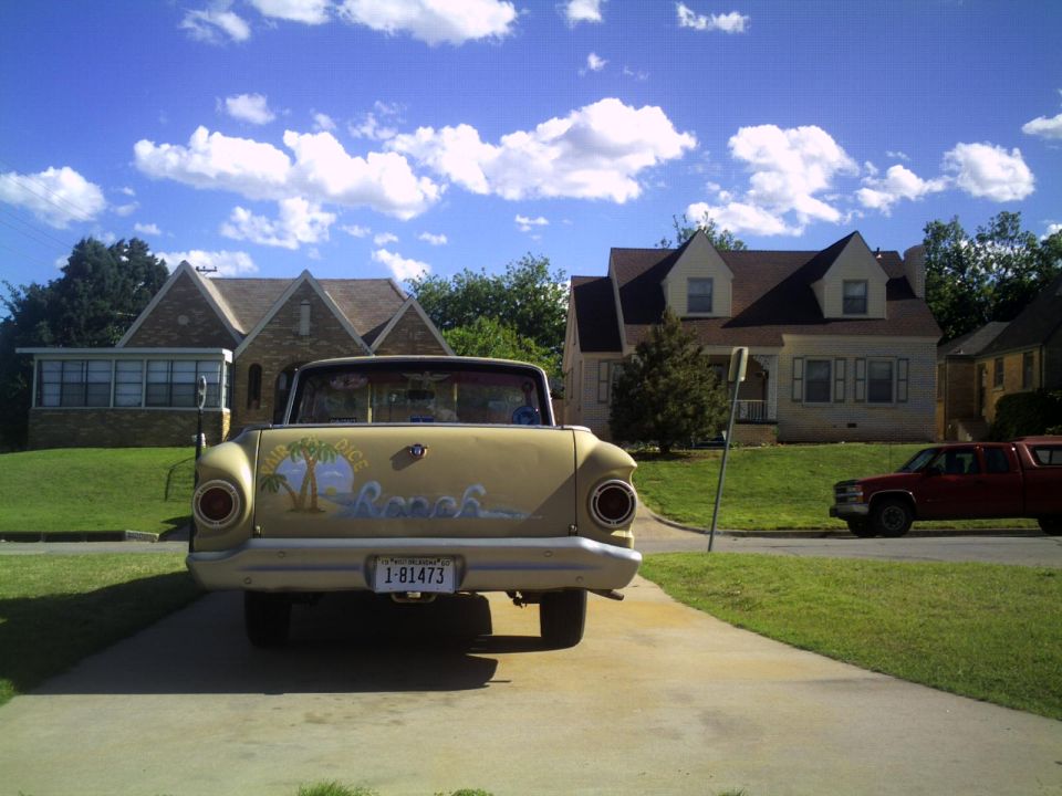 Rear view of a yellow 1972 Ford Ranchero with custom beach mural and license plate 1-81473