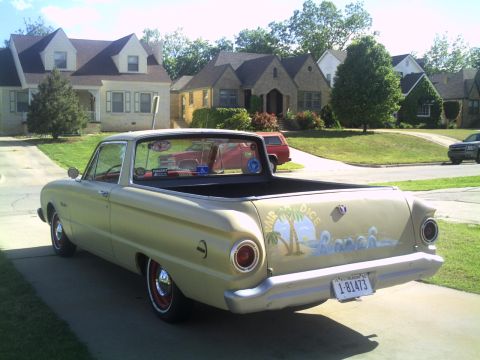 1972 Ford Ranchero - Three-quarter rear view of a gold early-1960s Ford Falcon Ranchero car-pickup parked in a residential driveway, showing round taillights, a…