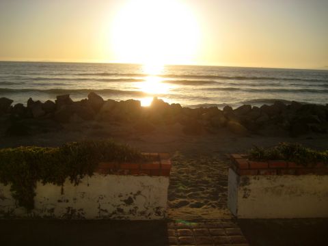 1996 Ford Bronco - The sun sets over the ocean, casting a warm glow on the water and beach.