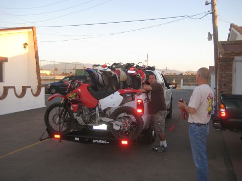1996 Ford Bronco - Pickup truck loaded with dirt bikes on a trailer, with two men standing next to it.
