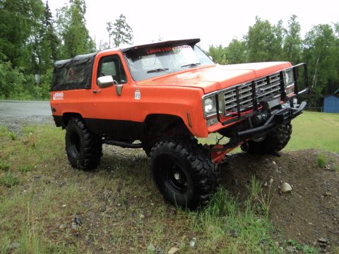 1990 Chevrolet Suburban - This modified SUV features a lift kit, oversized tires, and a custom front bumper with a winch.
