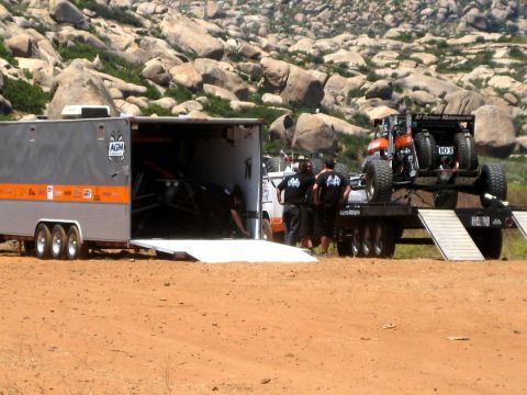 1996 Ford Bronco - Two off-road vehicles are being prepared for transport at a desert event.