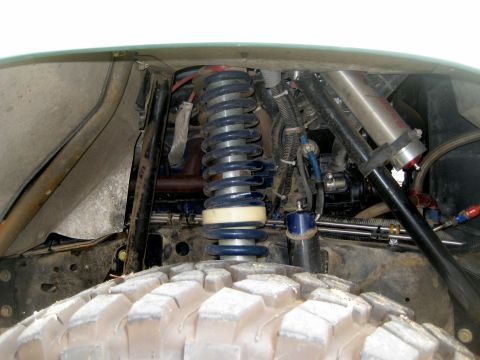 1996 Ford Bronco - Custom suspension components visible on an off-road vehicle's front wheel well.