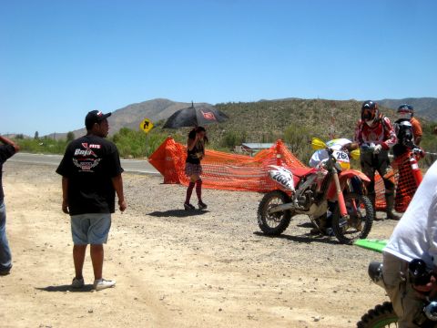 1996 Ford Bronco - Dirt bikes and participants gather at a race event, with temporary fencing set up in a desert landscape.
