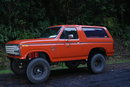 1983 Ford Bronco - This orange 1983 Ford Bronco features a lifted suspension and aggressive off-road tires, ready for adventure.