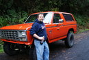 1983 Ford Bronco - Orange 1980 Ford Bronco with a man posing next to it in a wooded area.