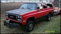 1991 GMC Suburban - This 1991 GMC Suburban is red with a black hood and roof, seen from the front-3/4 view.