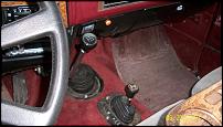 1991 GMC Suburban - Interior shot of a vehicle, showing the dashboard, two gear shifters, and red carpeting.