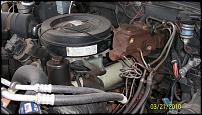 1991 GMC Suburban - Close-up view of an engine bay with various components and hoses.