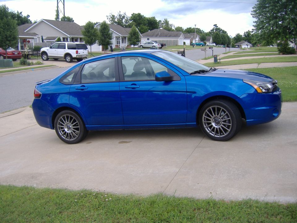Blue sedan parked on a driveway in a suburban neighborhood