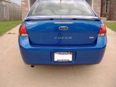 2010 Ford Focus - The rear of a blue sedan is visible, with a spoiler and license plate.