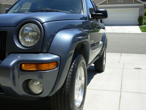 2002 Jeep Liberty - Front quarter view of a blue 2002 Jeep Liberty parked on a paved driveway.