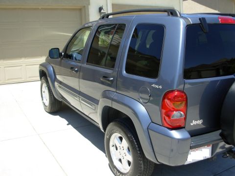 2002 Jeep Liberty - Rear passenger side view of a gray 2002 Jeep Liberty parked in a driveway.