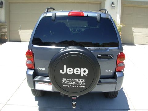 2002 Jeep Liberty - The rear of a Jeep Liberty is shown, a spare tire mounted on the back and a dealership advertisement on the tire cover.