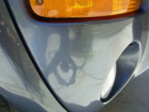 2002 Jeep Liberty - Close-up of the front corner of a gray SUV, showing the amber turn signal and some scuff marks on the bumper.