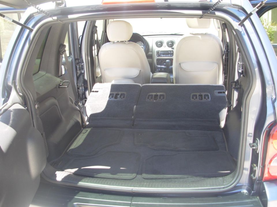 Back of a 2002 Jeep Liberty with seats folded down, showing cargo area and front seats