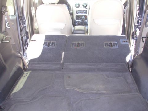 2002 Jeep Liberty - The folded-down rear seats of a 2002 Jeep Liberty reveal a carpeted cargo area and a view of the dashboard.