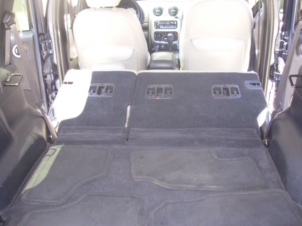 2002 Jeep Liberty interior, rear seats folded down, showing carpeted cargo area and dashboard