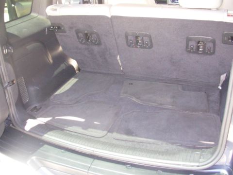 2002 Jeep Liberty - The cargo area of an SUV is shown with floor mats and seat latches visible.