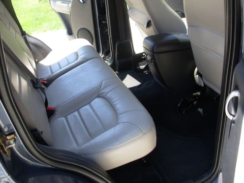 2002 Jeep Liberty - The rear interior of a 2002 Jeep Liberty features light gray leather seats and black carpeting.