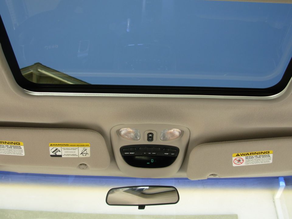 2002 Jeep Liberty interior showing sunroof, overhead console with lights and buttons, and sun visors