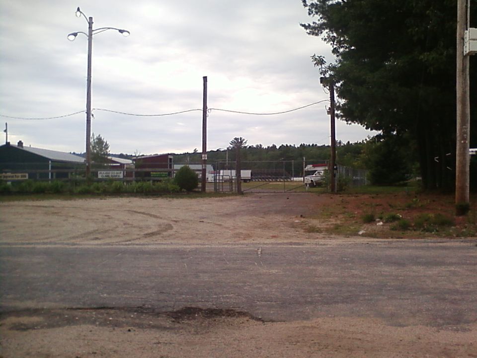 White pickup truck parked near a gate, distant view