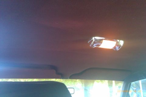 2000 Mercury Grand Marquis - The interior dome light of a vehicle is illuminated, with sun visors visible above the windshield.