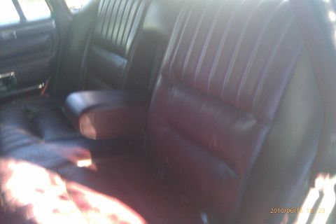 2000 Mercury Grand Marquis - Interior view of a dark leather car seat with a center armrest, illuminated by sunlight.