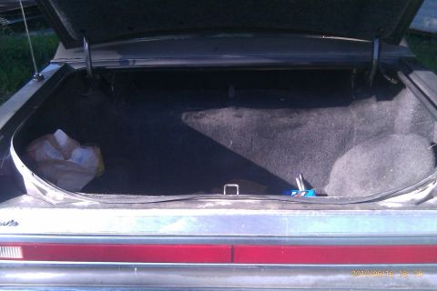 2000 Mercury Grand Marquis - Car trunk interior with items inside. The rear bumper and taillight bar are visible.