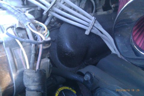 2000 Mercury Grand Marquis - Close-up view of an engine bay, showing various components and some fluid leakage.