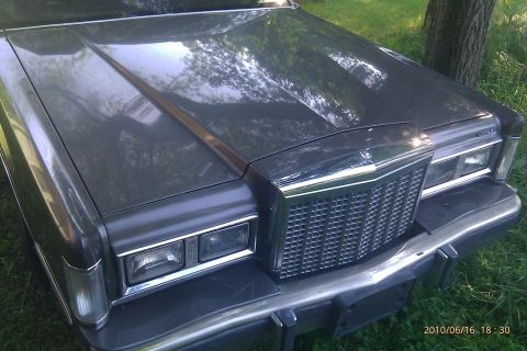 2000 Mercury Grand Marquis - Dark sedan's front end shows a large chrome grille and rectangular headlights.