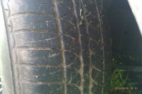 2000 Mercury Grand Marquis - The tire tread is worn and has debris stuck in it.
