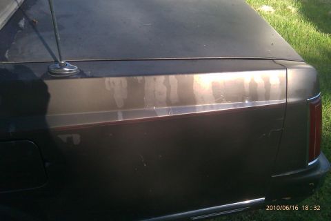 2000 Mercury Grand Marquis - Rear quarter panel of a car, showing an antenna and some paint imperfections.
