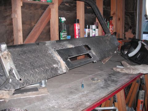 1991 Ford Bronco - A custom bumper part, likely for a truck or SUV, sits on a workbench with welding supplies nearby.