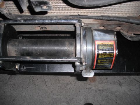 1991 Ford Bronco - A close-up view of a vehicle's winch mechanism, including its drum and safety instructions.