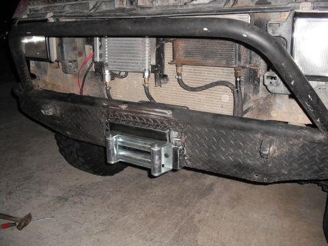 1991 Ford Bronco - Aftermarket winch and auxiliary coolers installed on a vehicle's front bumper.