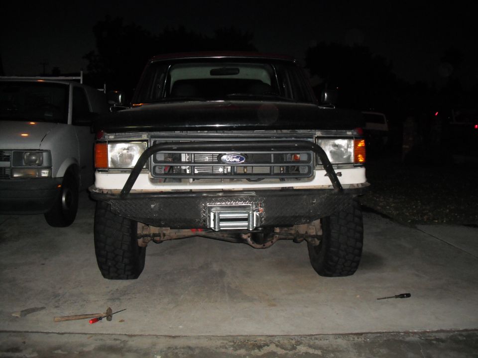 1991 Ford Bronco front end with custom bumper and winch. Another vehicle is parked to the left