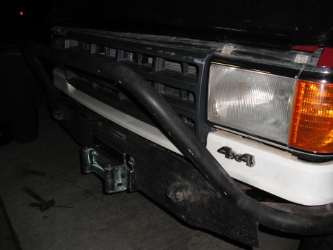 1991 Ford Bronco - Close-up of a front bumper a winch and a 4x4 badge.