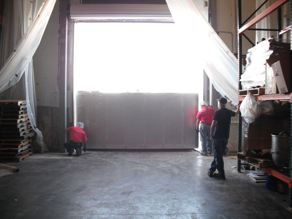 Loading dock door being closed by workers