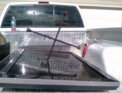 2006 Ford E350 - Items are loaded in the bed of a white pickup truck, including a toolbox and a flat screen television.
