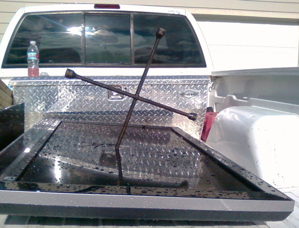 Truck bed with a toolbox, a flat screen TV, and a lug wrench